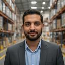 Portrait of Rasul Muse, Logistics Manager at a busy Irish distribution centre, standing confidently in a warehouse